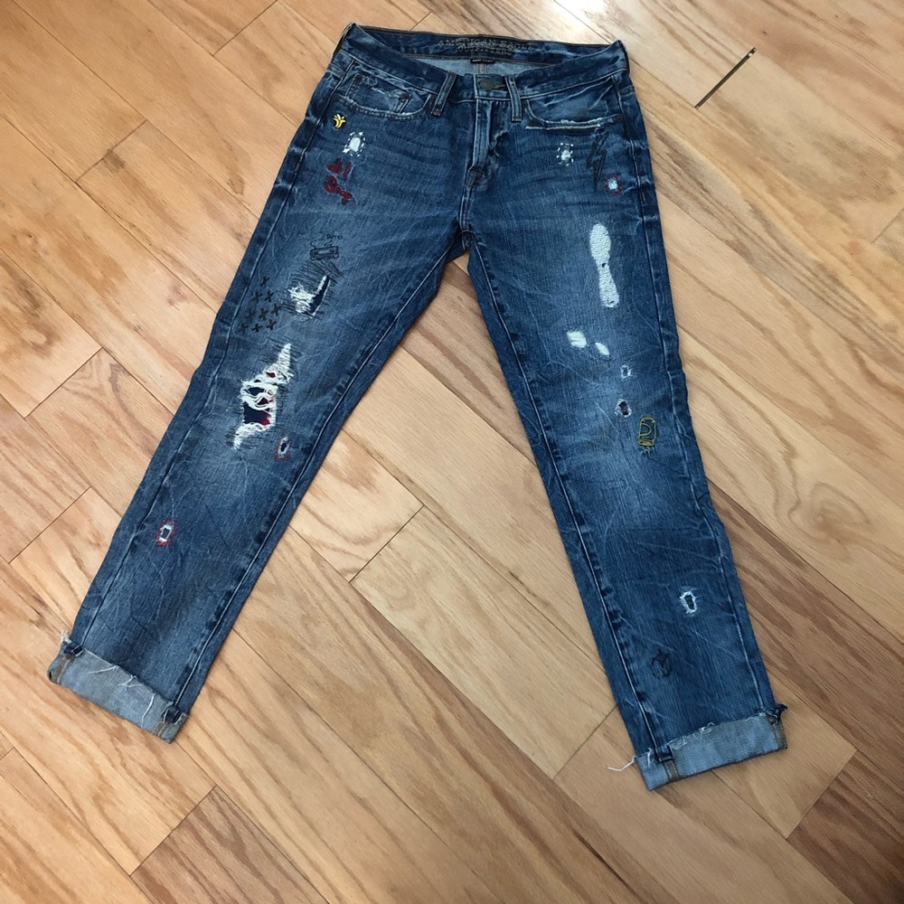 American Eagle distressed and embroidered jeans various patches throughout